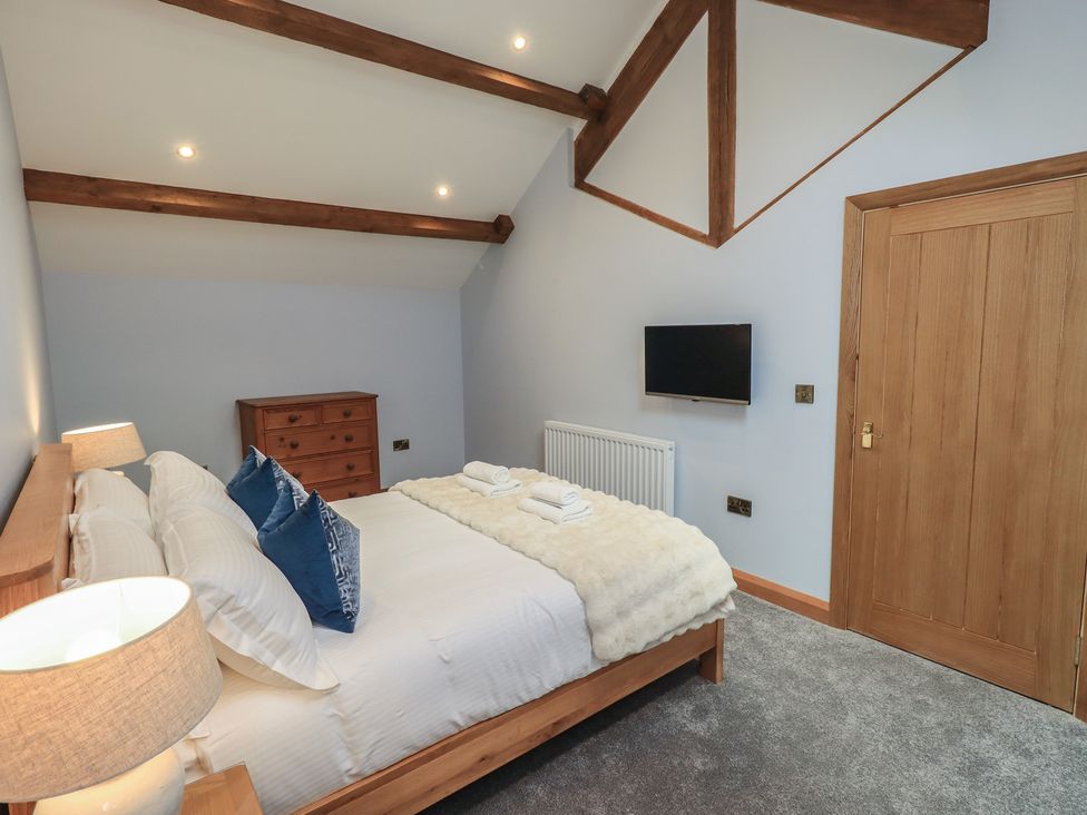 A bedroom with a bed and a dresser at Dam House Barn in Austwick