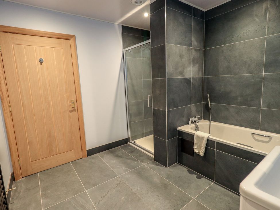 A bathroom with a shower and bathtub at Dam House Barn in Austwick