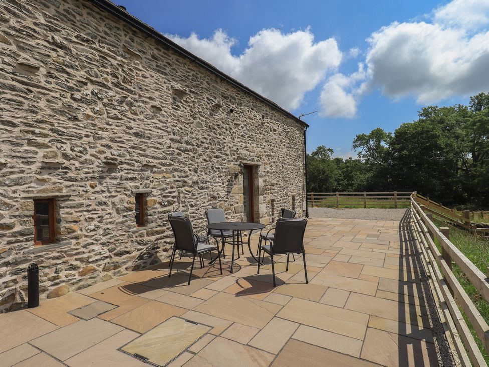 An outdoor patio with stone wall at Dam House Barn in Austwick