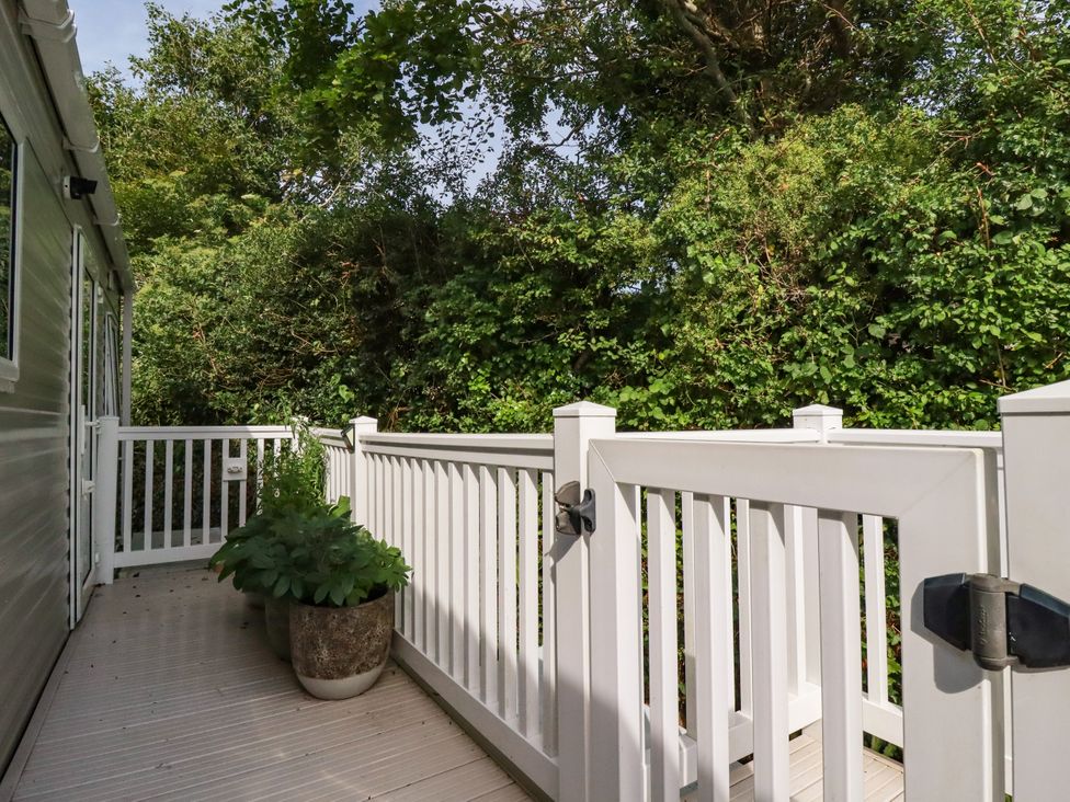 A deck area with railing and plants at 5 Silverbow