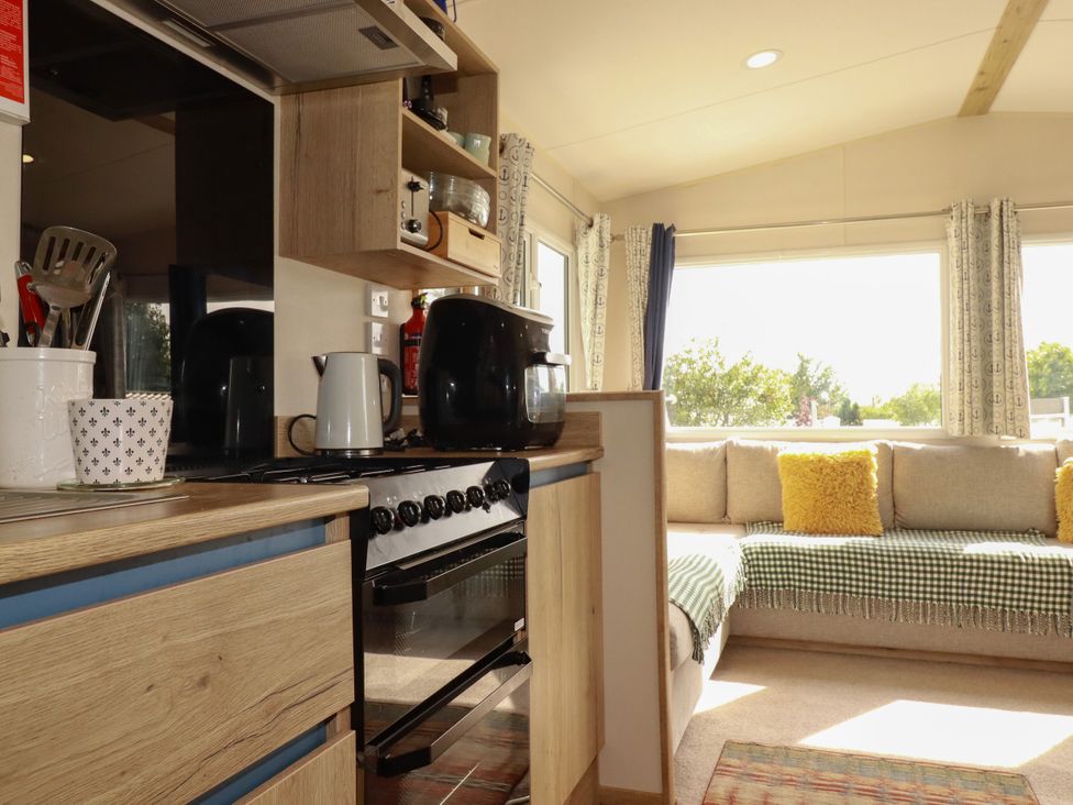 A kitchen area with a stove and sofa in a living room at 5 Silverbow