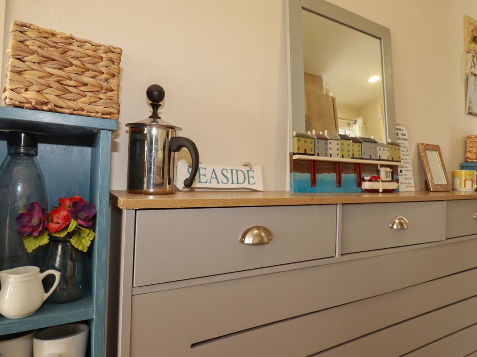 A living room with a drawer unit and decorative items at 5 Silverbow