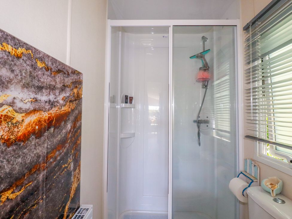 A bathroom with a shower and toilet at Porthcurno 5, Perranwell near Goonhavern