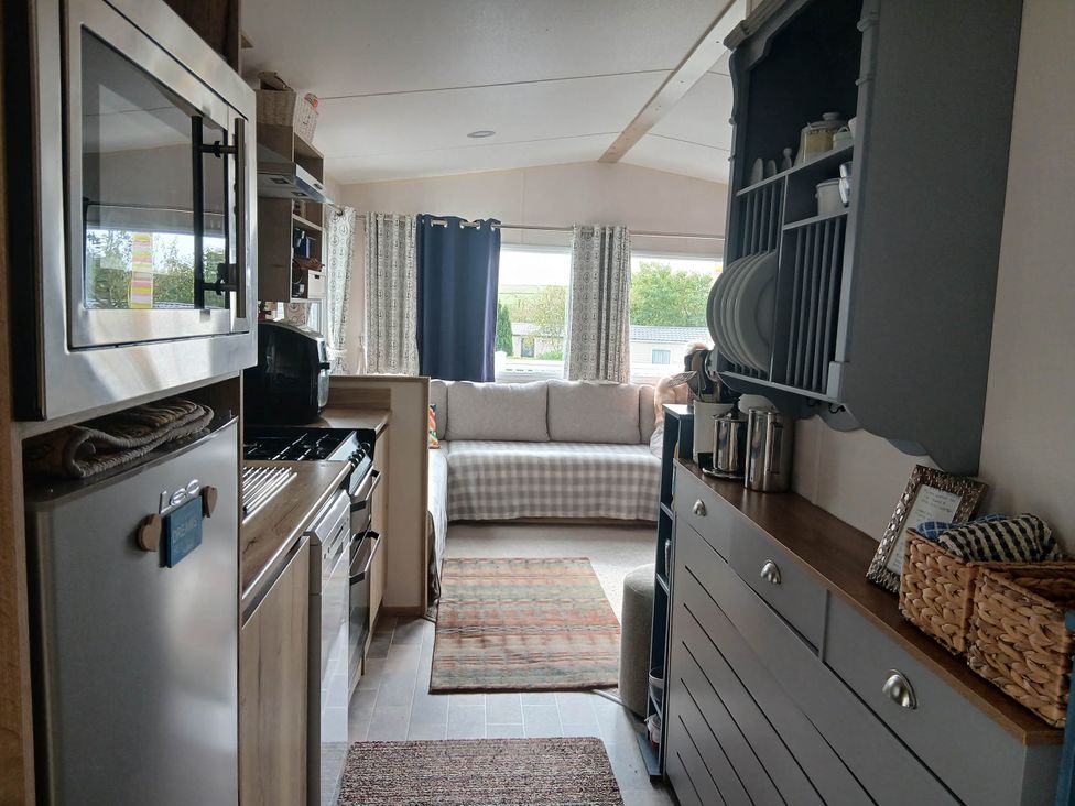 A kitchen with cabinets and a couch at Porthcurno 5 Perranwell near Goonhavern