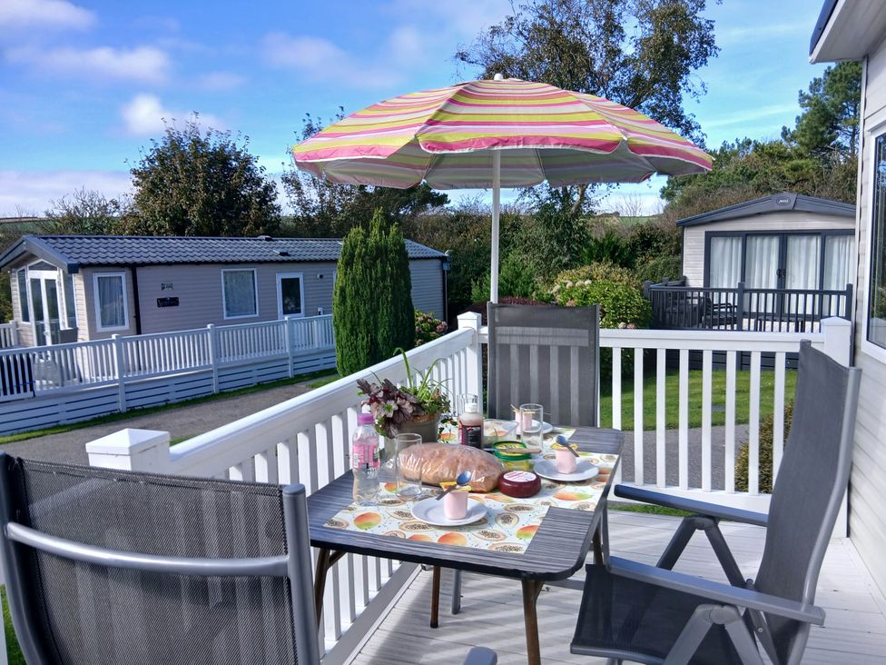 A table with food and drinks on a deck at Porthcurno 5 in Perranwell near Goonhavern