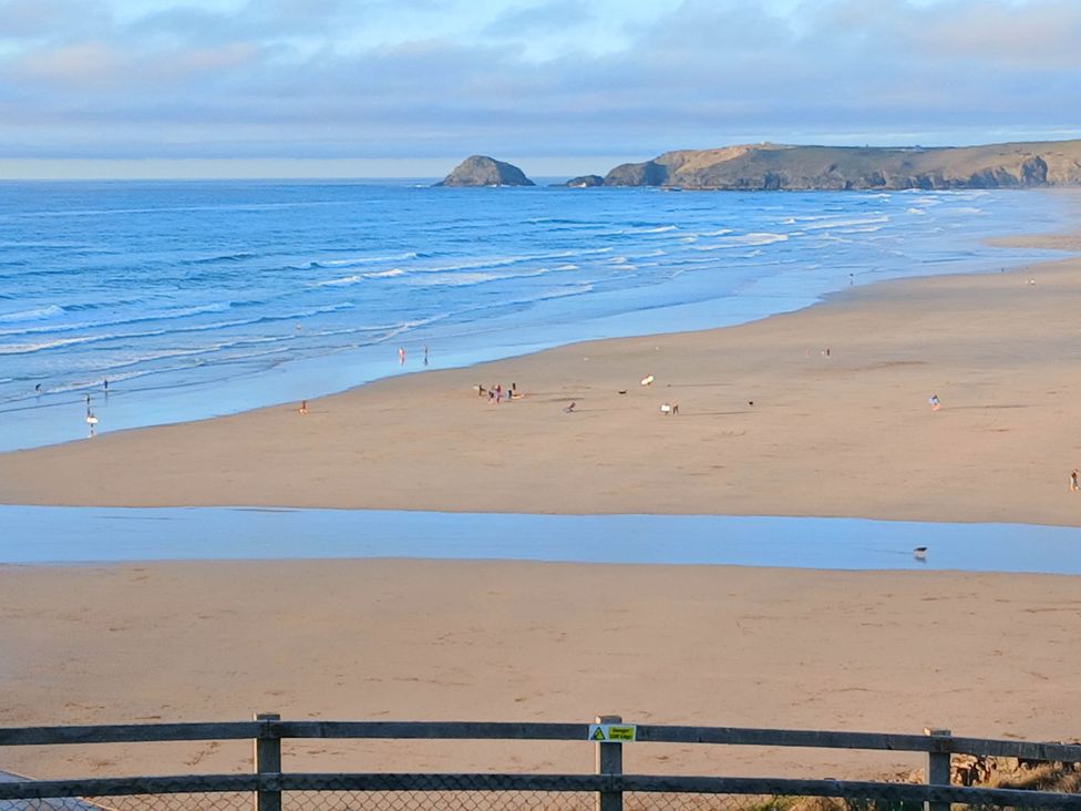 A beach with people walking and waves at Porthcurno 5 in Perranwell near Goonhavern