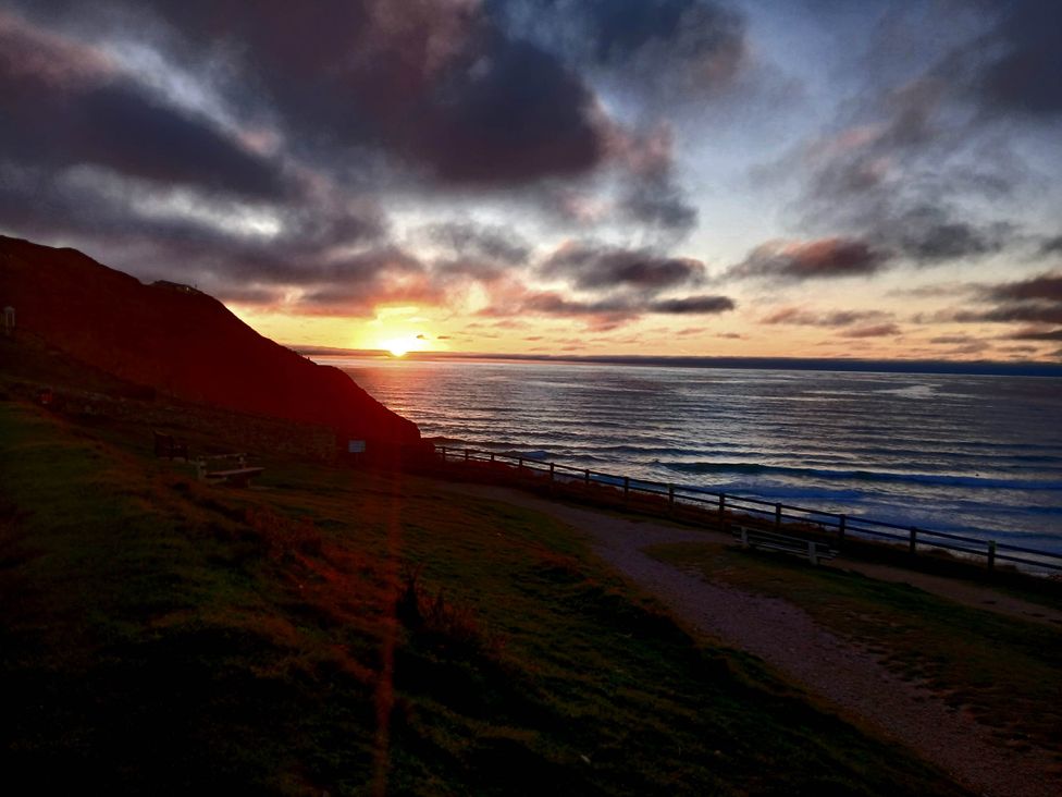 A sunset over the ocean with a path by the sea at Porthcurno 5 Perranwell near Goonhavern