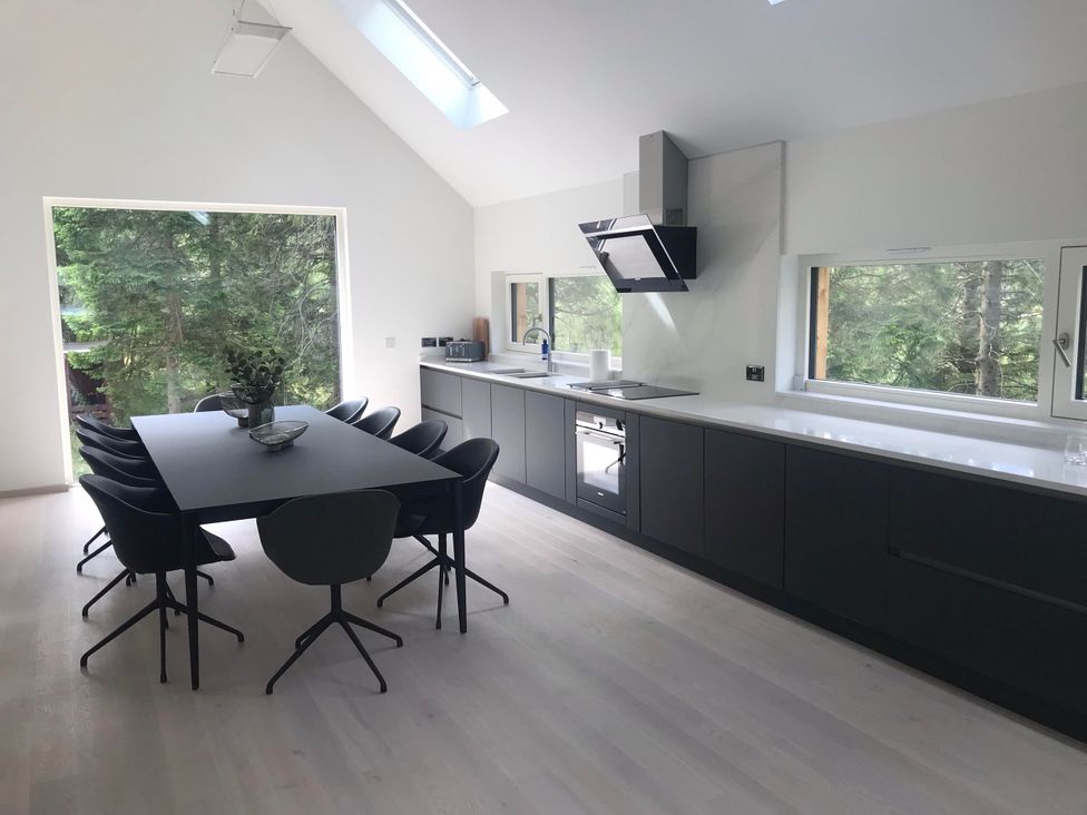 A kitchen with dining table and chairs at Red Stag with stunning loch and waterfall view, Crianlarich