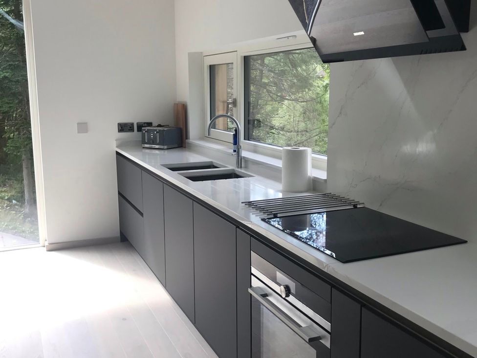 A kitchen with a sink and cooker at Red Stag with stunning loch and waterfall view, Crianlarich