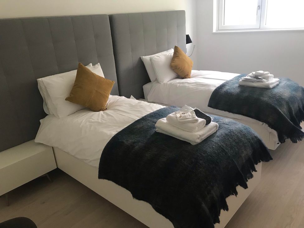 A bedroom with two single beds at Red Stag with stunning loch and waterfall view in Crianlarich