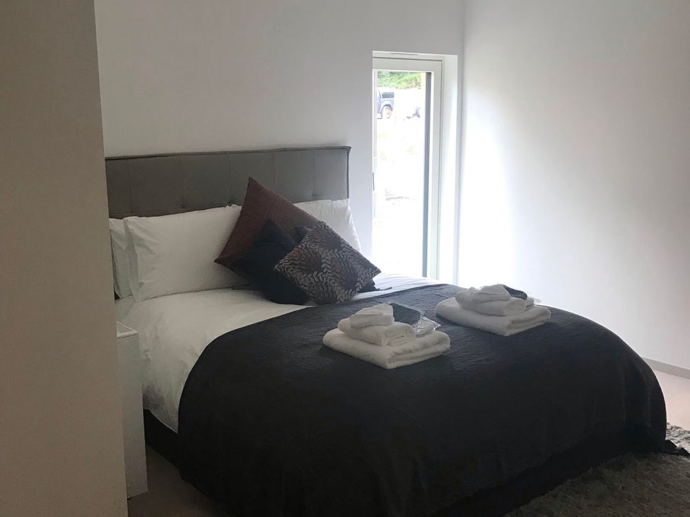 A bedroom with a bed and towels at Red Stag with stunning loch and waterfall view in Crianlarich