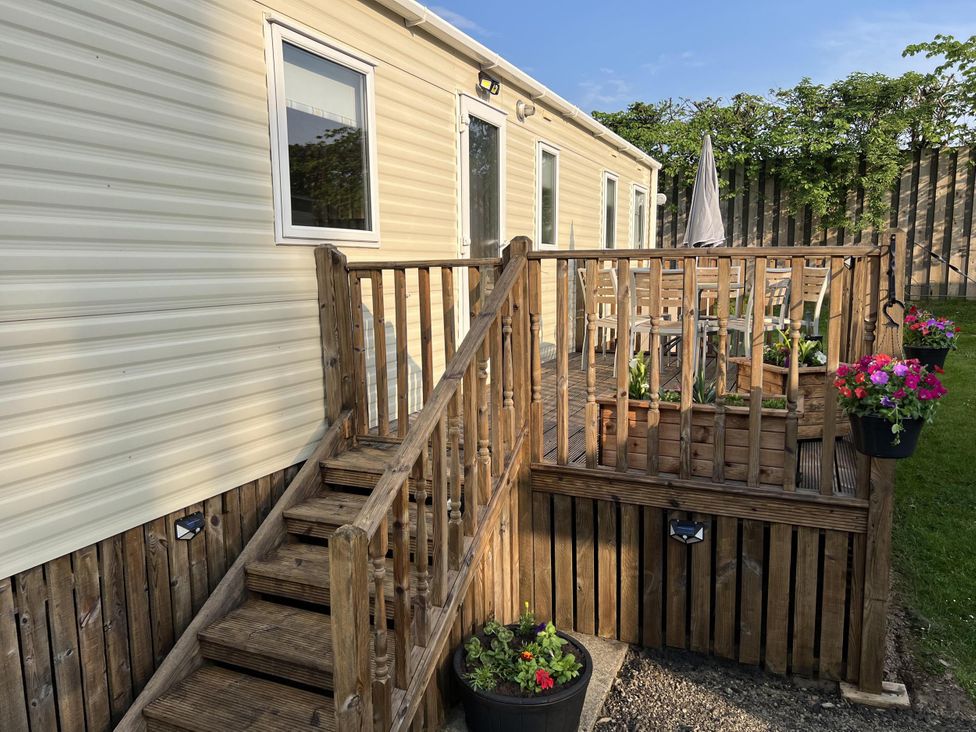 An outdoor area with a caravan and wooden deck at Hornshole Hideaway Caravan Hawick