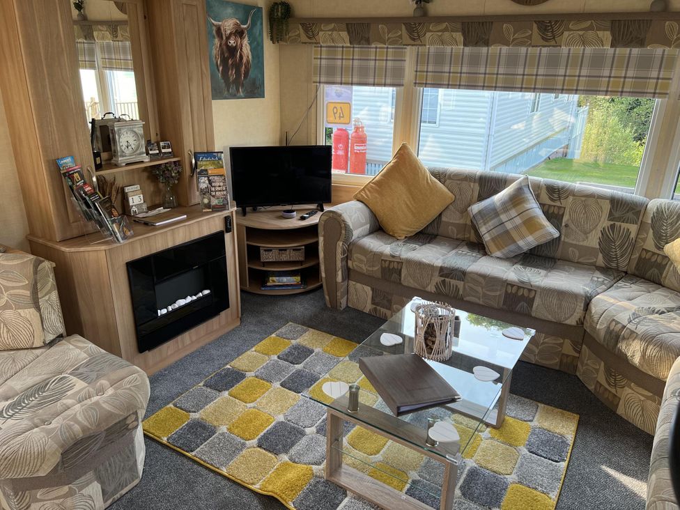 A living room with a television and sofa at Hornshole Hideaway Caravan Hawick Riverside Caravan Park near Hawick