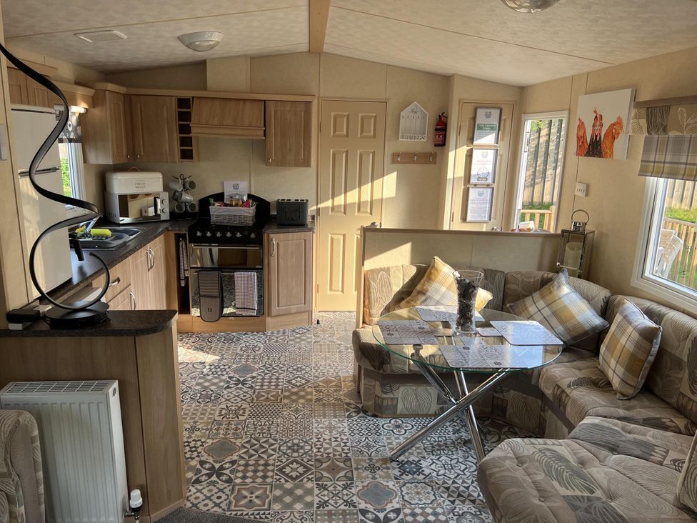 A living room with a kitchenette and seating area at Hornshole Hideaway Caravan Hawick Riverside Caravan Park near Hawick