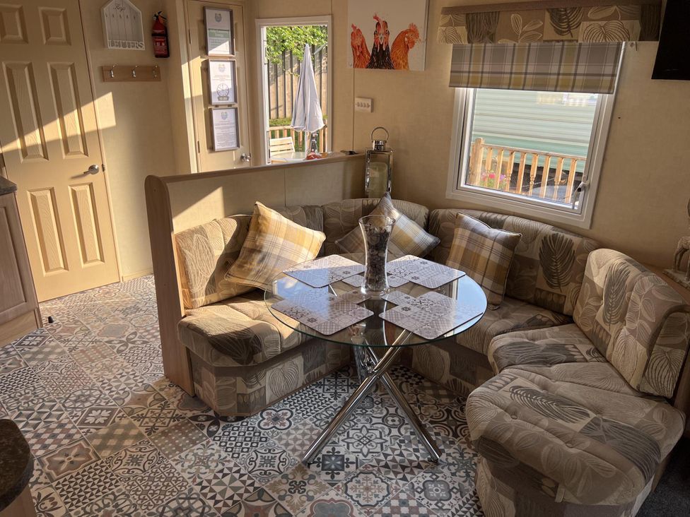 A living room with a sofa and table at Hornshole Hideaway Caravan Hawick