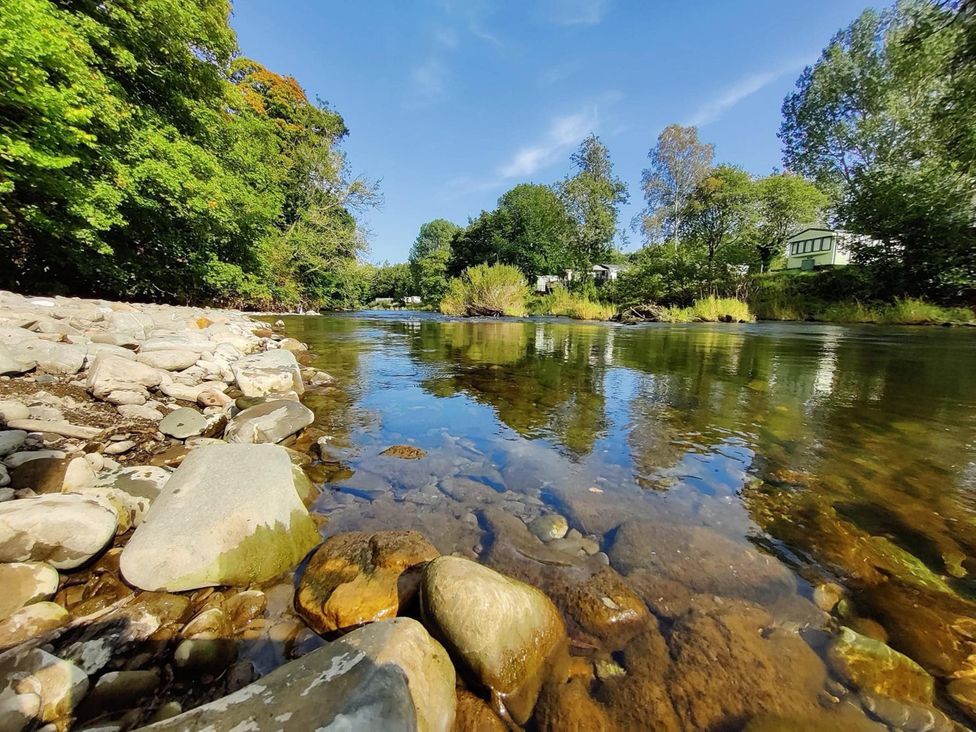 A river with rocks and trees at Hornshole Hideaway Caravan Hawick near Riverside Caravan Park near Hawick