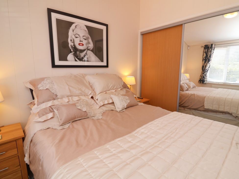 A bedroom with a bed and lamp at Banksy in Mullacott Park near Ilfracombe