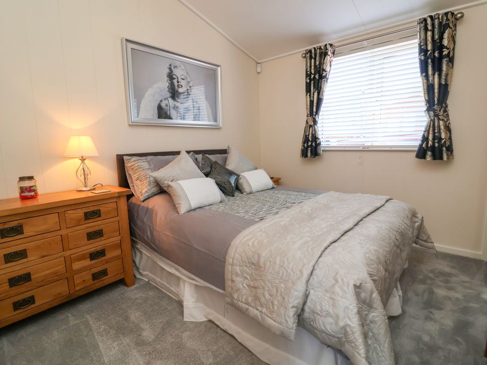 A bedroom with a bed and a dresser at Banksy in Mullacott Park near Ilfracombe