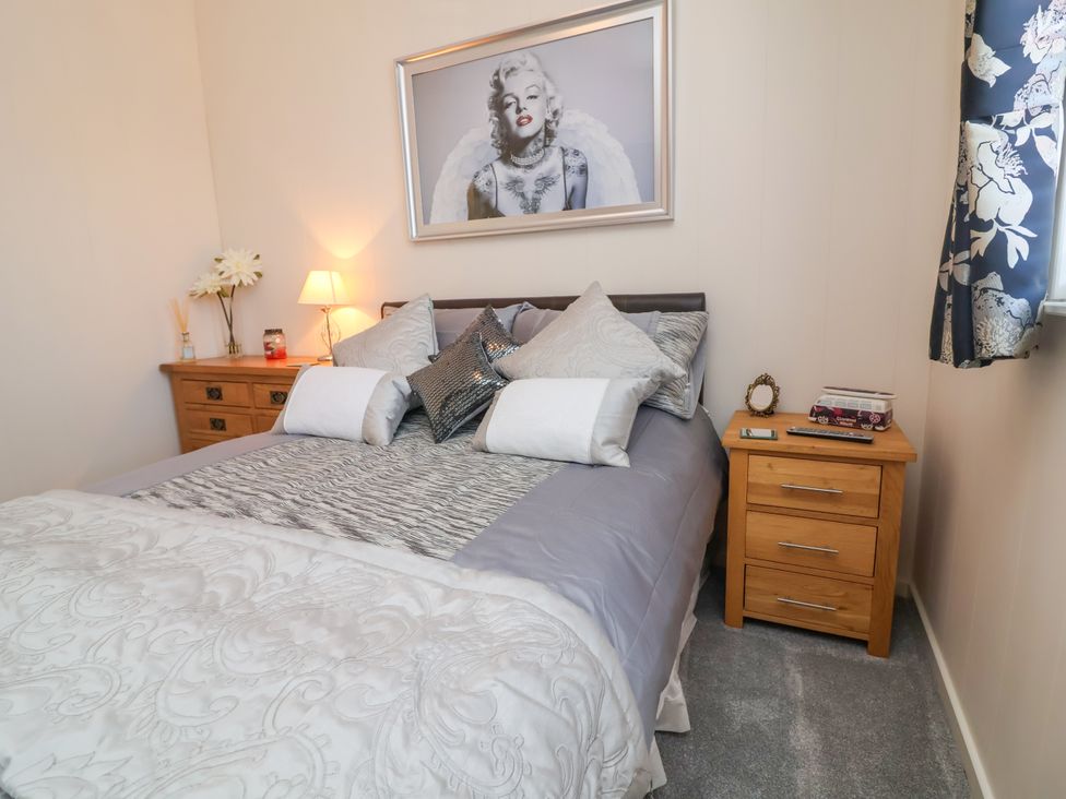 A bedroom with a bed and bedside table at Banksy Mullacott Park near Ilfracombe