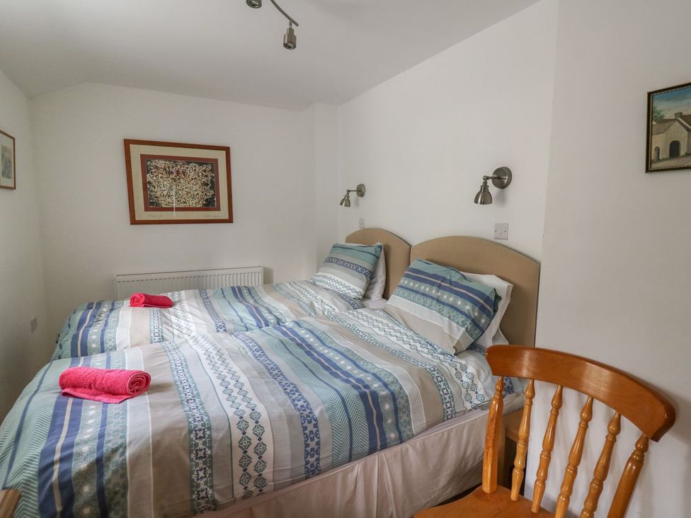 A bedroom with two beds and a chair at Tegfan in Newport