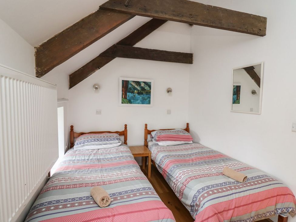 A bedroom with two beds and a table at Tegfan in Newport