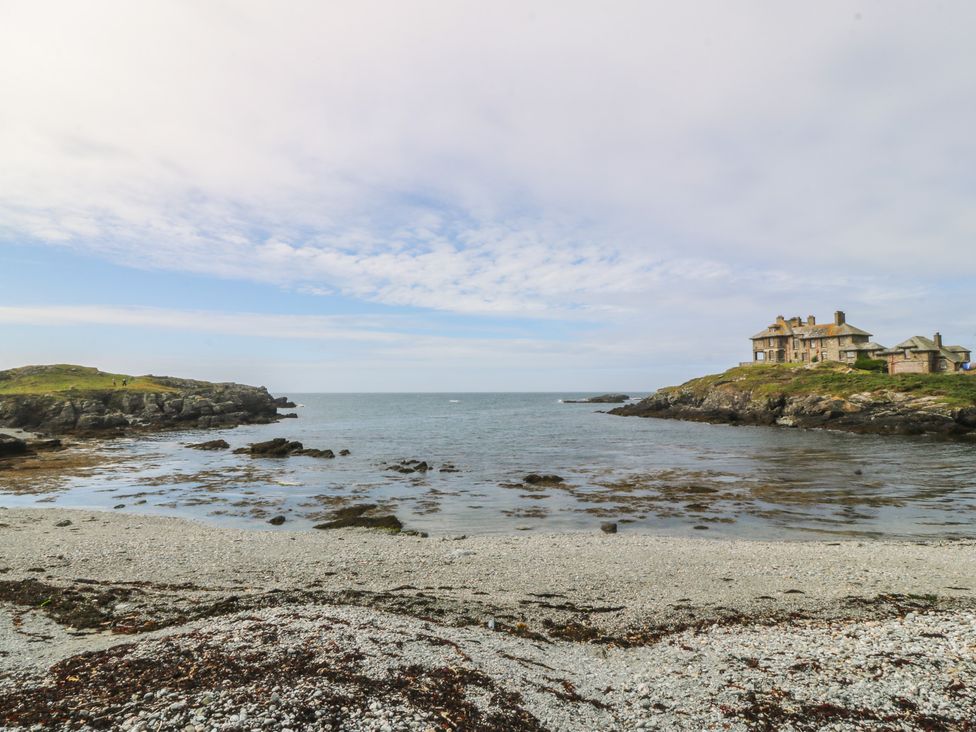 A beach with rocks and a house at Porth Ewyn House in Trearddur Bay