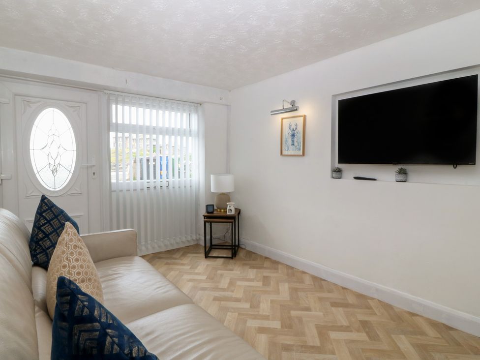 A living room with a sofa and television at Porth Ewyn House Trearddur Bay