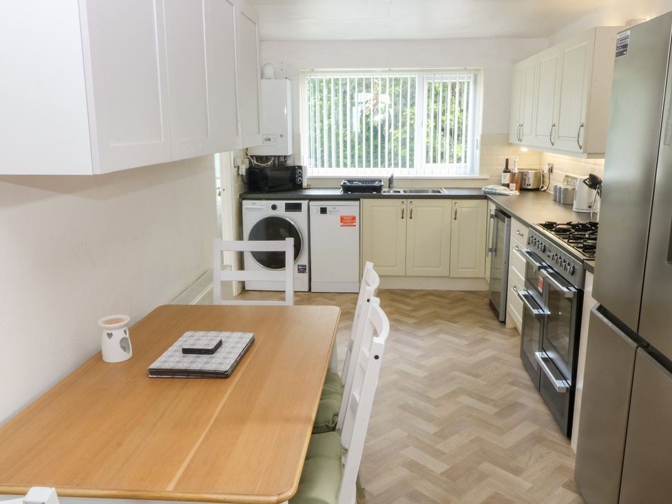 A kitchen with appliances and a table at Porth Ewyn House Trearddur Bay