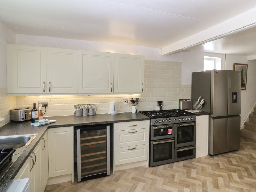 A kitchen with cabinets, cooking range and refrigerator at Porth Ewyn House Trearddur Bay