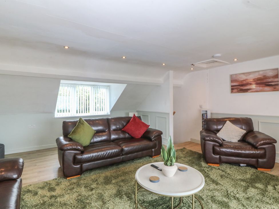 A living room with sofas and a table at Porth Ewyn House in Trearddur Bay