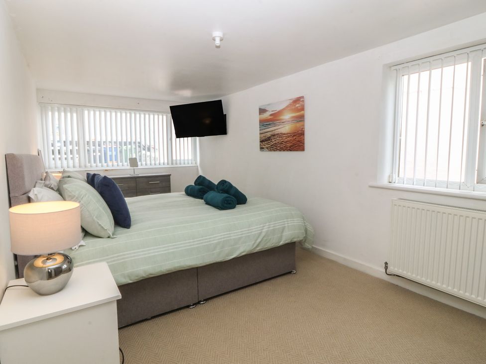 A bedroom with a bed and television at Porth Ewyn House, Trearddur Bay