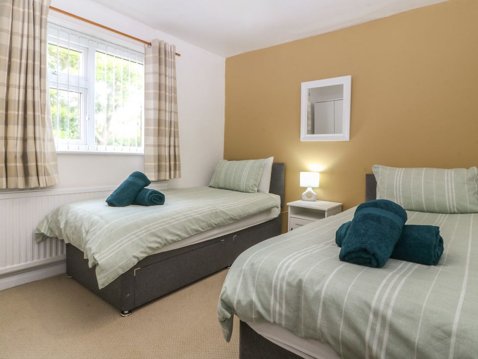 A bedroom with two beds and a lamp at Porth Ewyn House Trearddur Bay