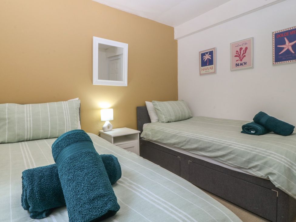 A bedroom with two beds and towels at Porth Ewyn House, Trearddur Bay