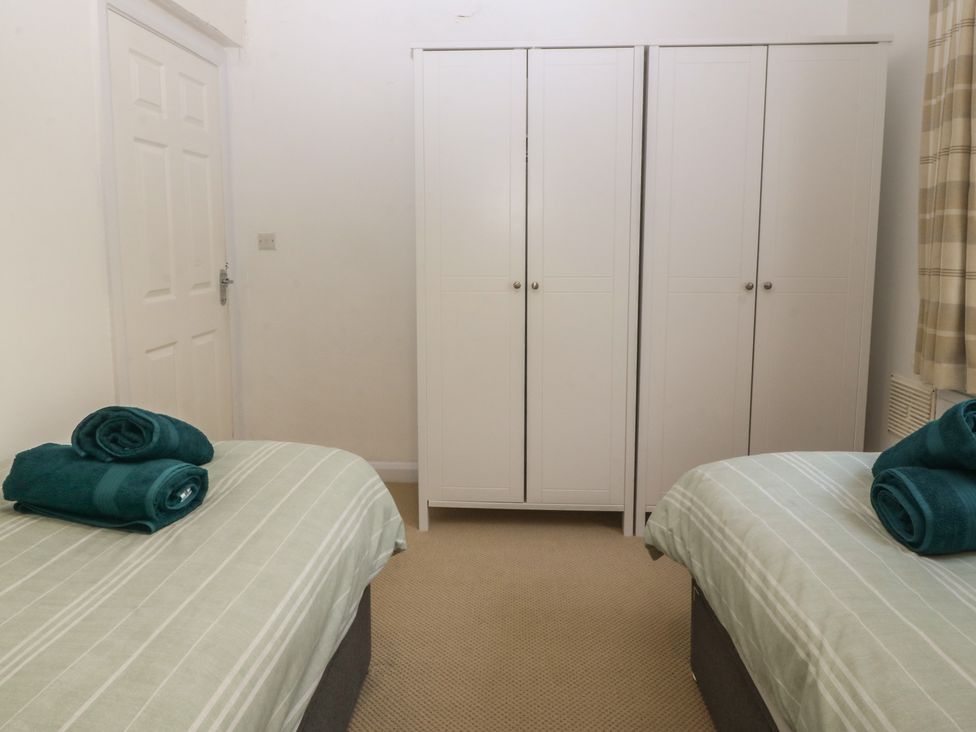 A bedroom with twin beds and a wardrobe at Porth Ewyn House, Trearddur Bay