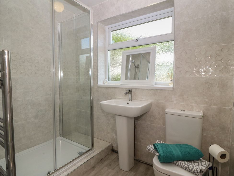 A bathroom with a shower, sink, and toilet at Porth Ewyn House in Trearddur Bay