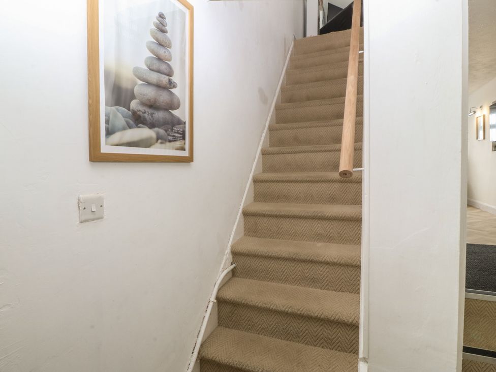 A staircase with a framed picture and light switch at Porth Ewyn House in Trearddur Bay