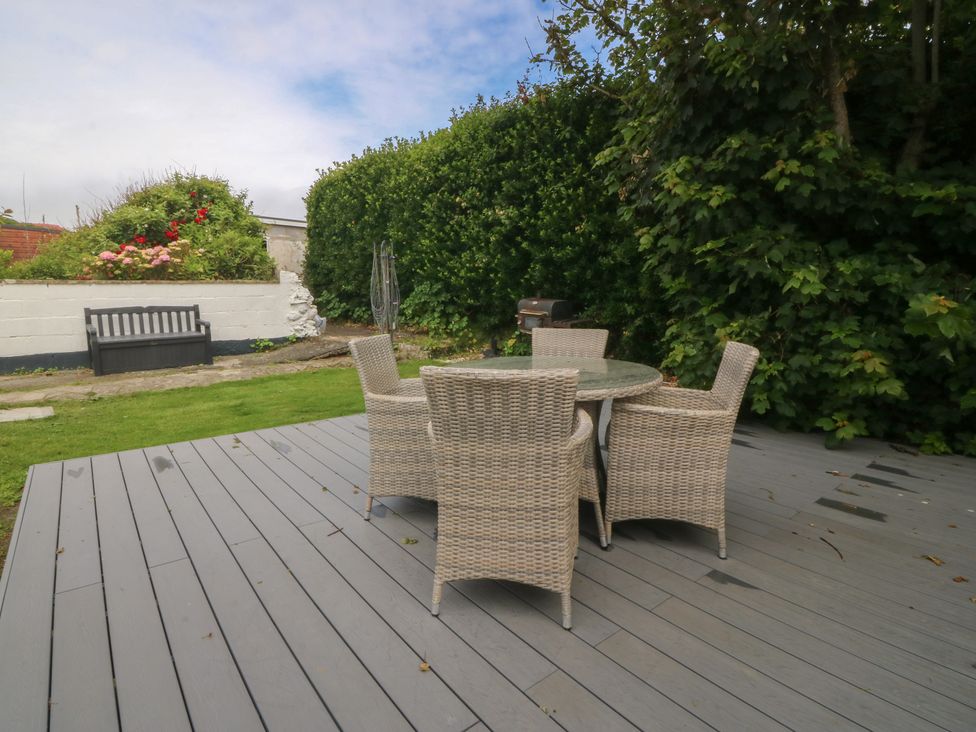An outdoor table with chairs in a garden at Porth Ewyn House Trearddur Bay