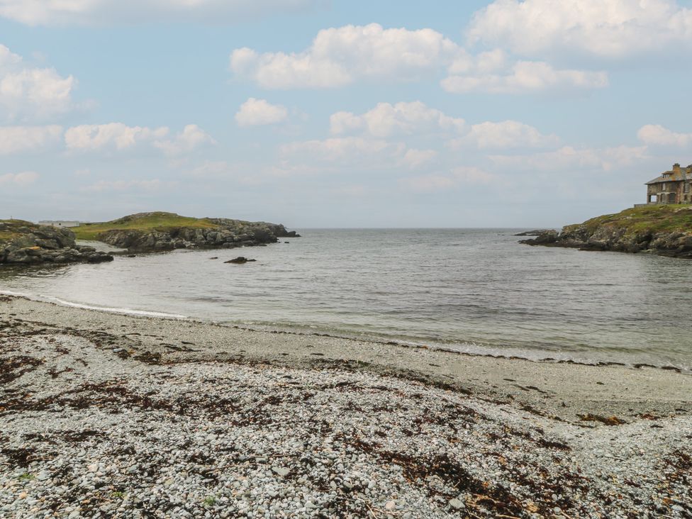 A beach with water and rocks at Porth Ewyn House in Trearddur Bay