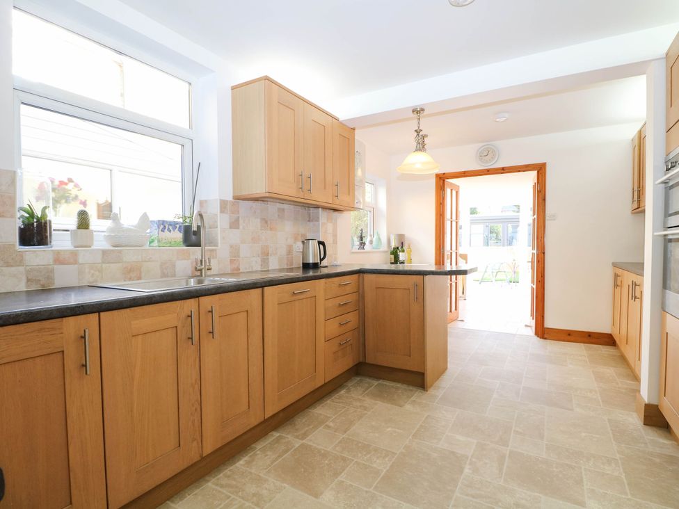 A kitchen with wooden cabinets and a sink at Fernleigh in Margate