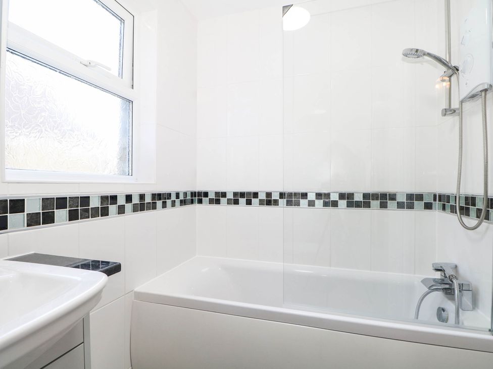 A bathroom with a bathtub, shower, and sink at Fernleigh in Margate