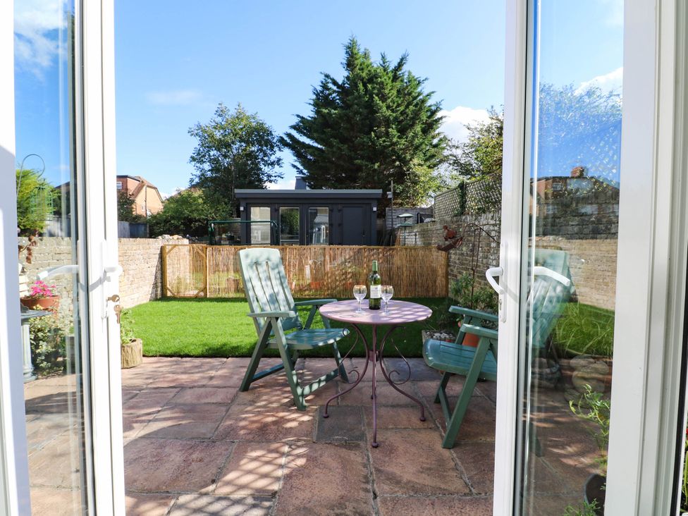 A garden with green chairs and a table at Fernleigh in Margate