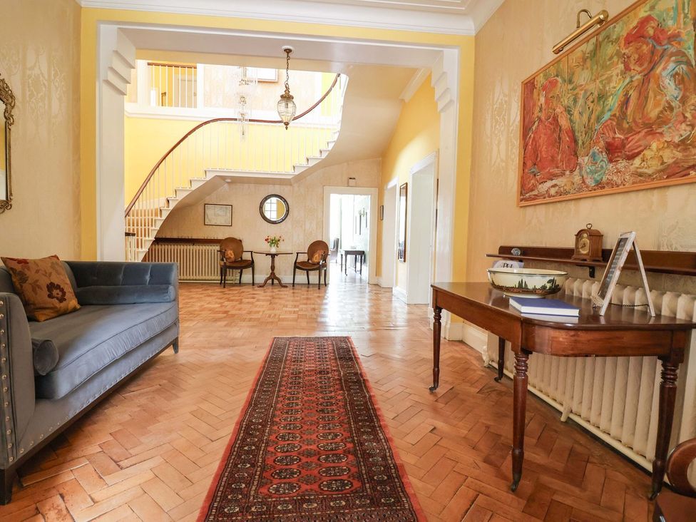 A hallway with a staircase and a sofa at Parkfields House in Stoke-on-Trent