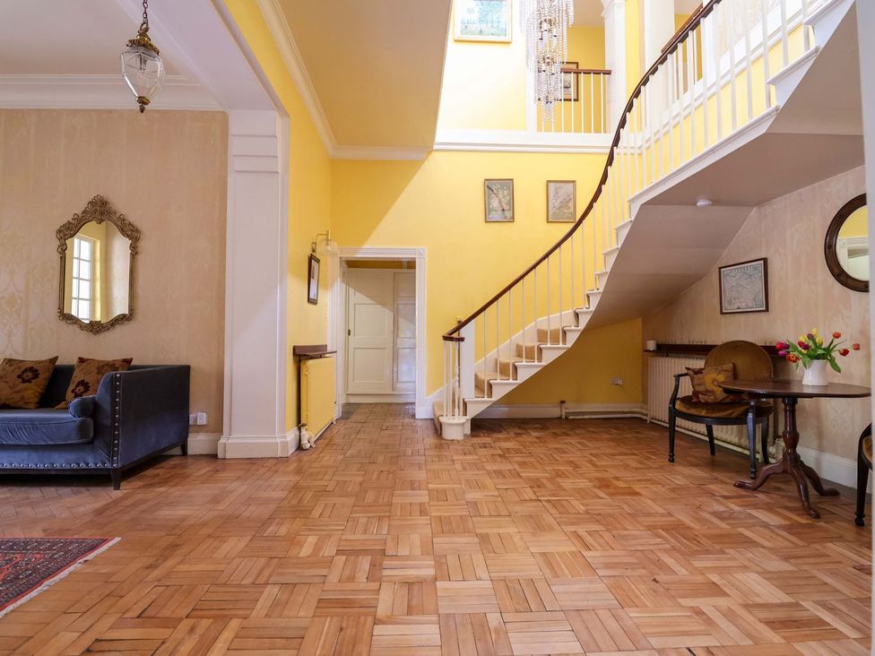 A hallway with a staircase and a sofa at Parkfields House Stoke-on-Trent