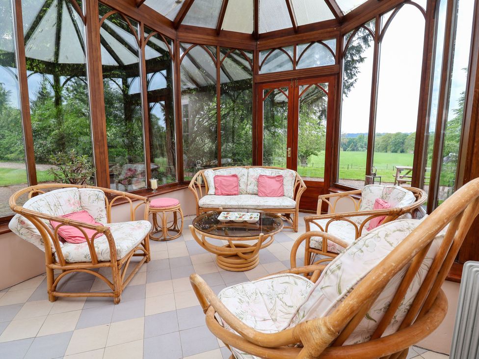 A conservatory with seating and a coffee table at Parkfields House in Stoke-on-Trent