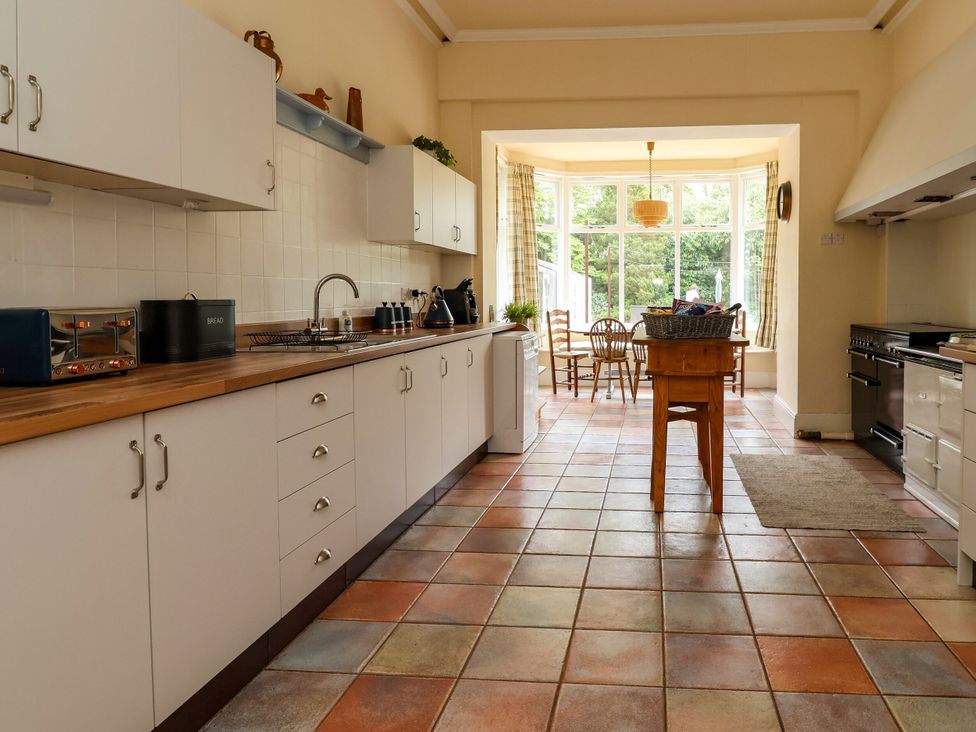A kitchen with cabinets and a table at Parkfields House in Stoke-on-Trent