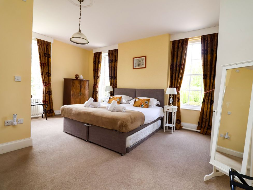 A bedroom with a bed and wardrobe at Parkfields House in Stoke-on-Trent