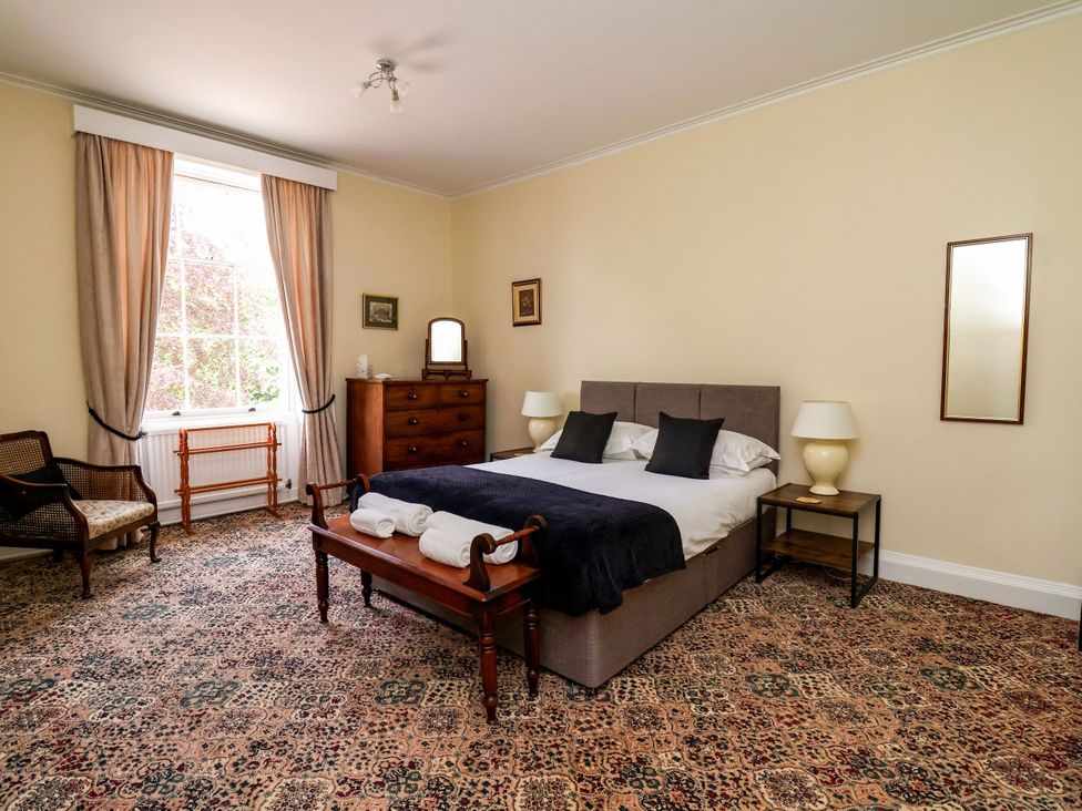 A bedroom with a bed and nightstands at Parkfields House in Stoke-on-Trent