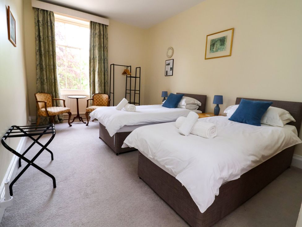 A bedroom with two beds and a table at Parkfields House Stoke-on-Trent