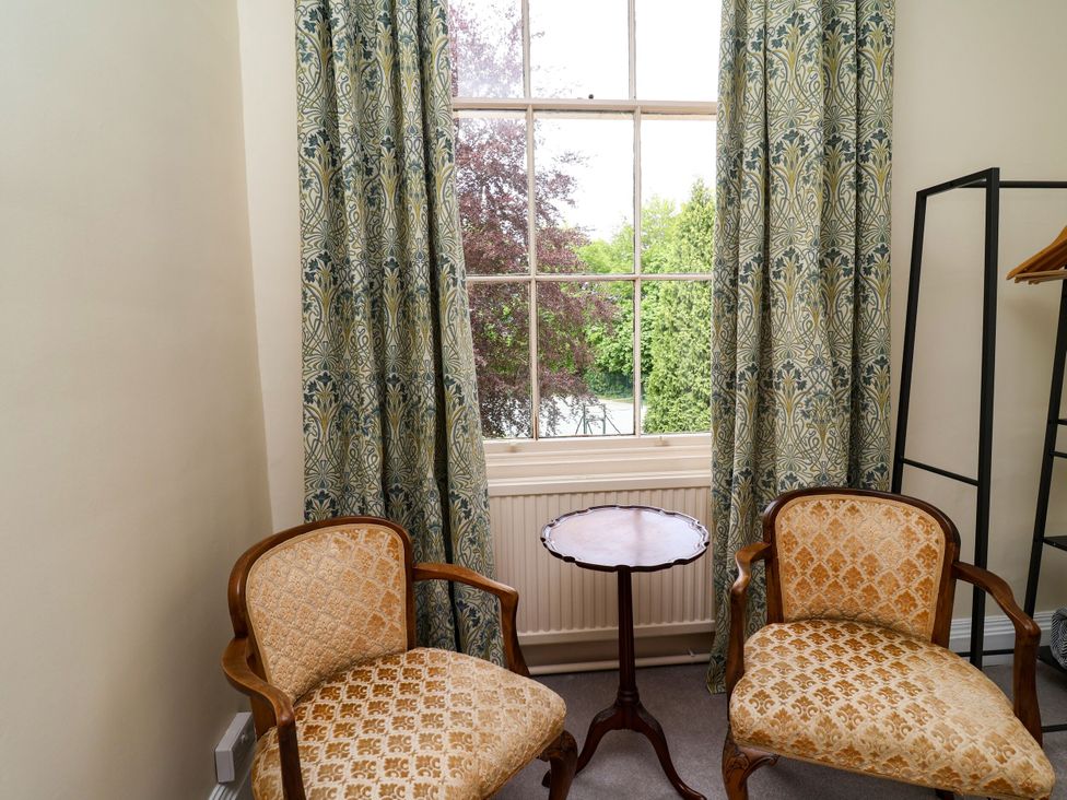 A sitting room with two chairs and a table near a window at Parkfields House Stoke-on-Trent
