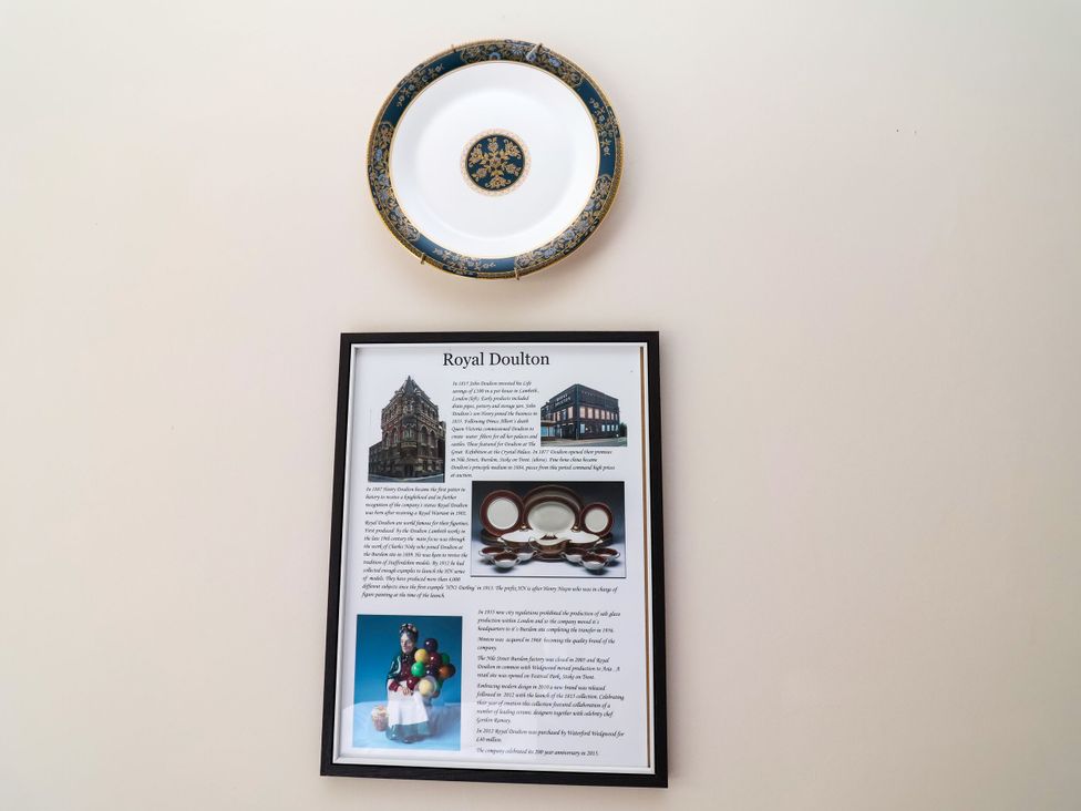 A decorative plate and framed information about Royal Doulton